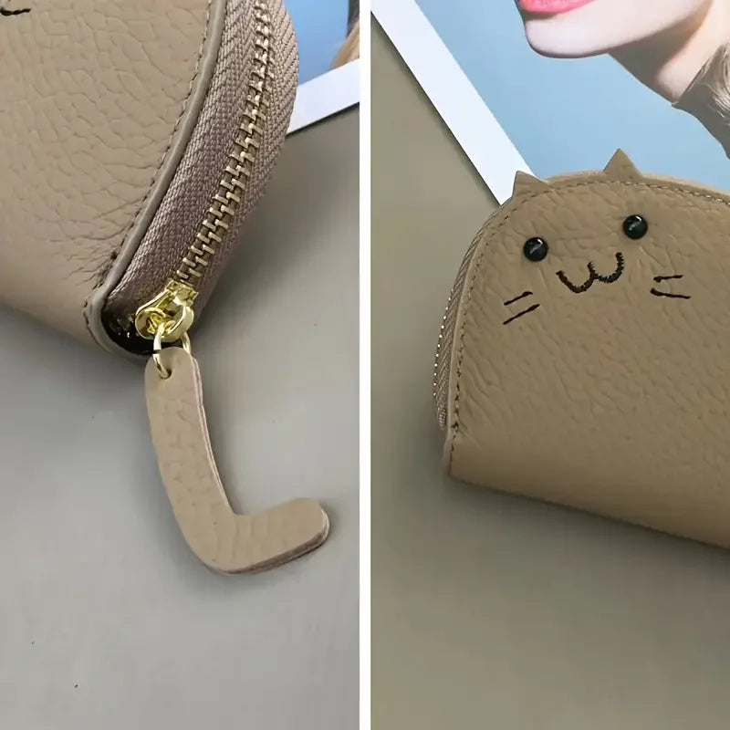 A light beige faux leather wallet with a cartoon cat design and a leather charm.