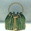 A dark green crystal-embellished evening clutch featuring gold chain detailing and a gold-toned rim.