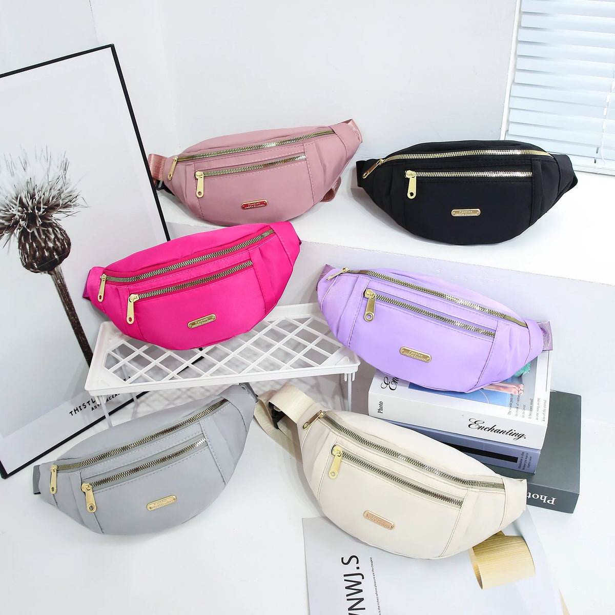 A collection of pink, purple, and black lightweight nylon crossbody fanny packs displayed on a white surface.