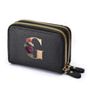 Black faux leather mini wallet with a gold letter G print and a double zipper.