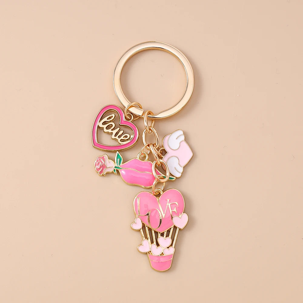 A gold-colored enamel heart keychain featuring a love heart and a pink flower design.