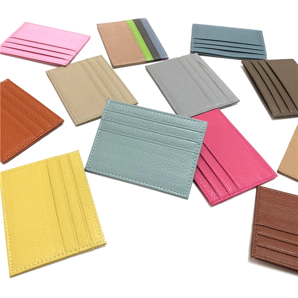 Eine Sammlung verschiedenfarbiger, echter Kuhfell-ID-Card-Haltertaschen auf weißem Hintergrund.