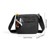 Black plaid water resistant crossbody shoulder bag with a strap and charm