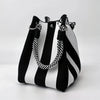 A black and white striped retro knitted bucket handbag with silver hardware.