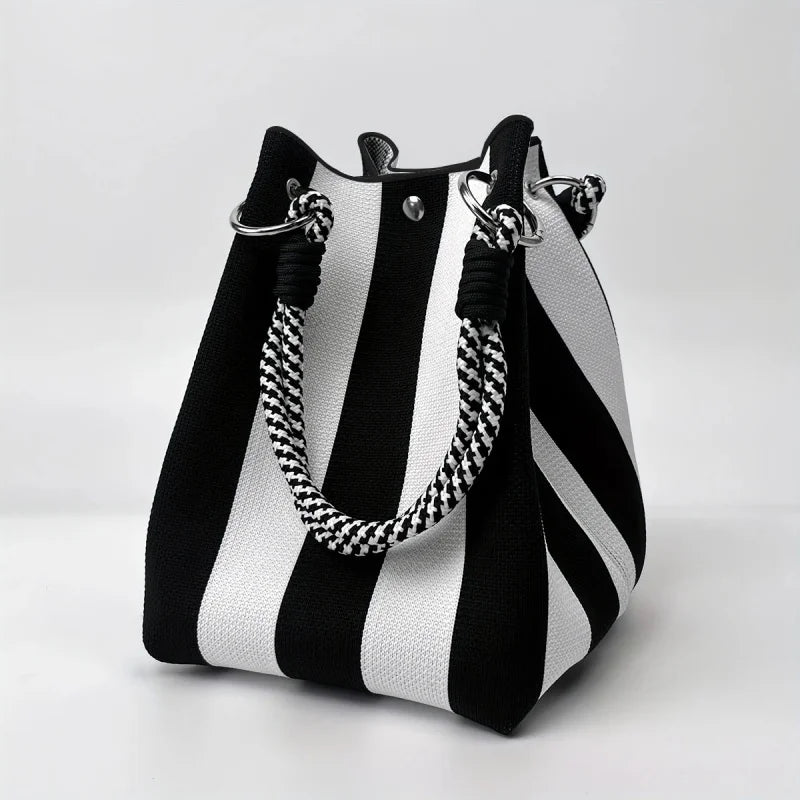 A black and white striped retro knitted bucket handbag with silver hardware.