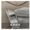 Close-up of a silver rhinestone-embellished crossbody bag with an adjustable strap against a neutral background.