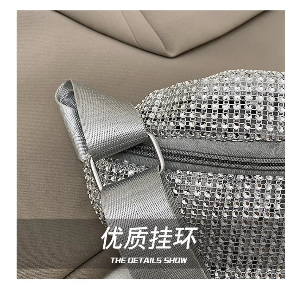 Close-up of a silver rhinestone-embellished crossbody bag with an adjustable strap against a neutral background.