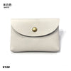A light beige genuine leather card holder or coin purse with a folded flap and a round brass stud detail.