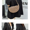A dark brown faux suede hobo crossbody bag with gold rivet accents worn by a woman.