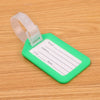 A green plastic luggage tag with a clear window and lines for writing name, address, and city/state, attached to a white stra