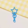 A blue star shaped metal keychain clasp set resting on a yellow checkered cloth.