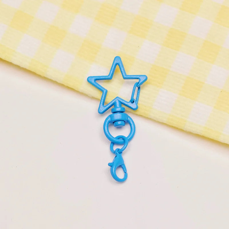 A blue star shaped metal keychain clasp set resting on a yellow checkered cloth.