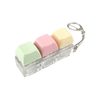 A clear plastic keyboard fidget toy with five pastel colored silicone keys and a metal clip.
