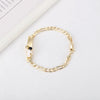 A gold-colored chain bracelet featuring a small white heart charm.