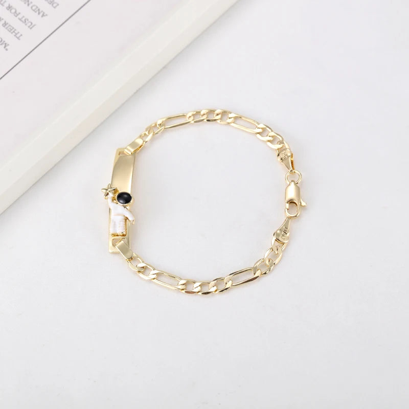 A gold-colored chain bracelet featuring a small white heart charm.