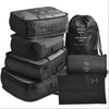 A set of seven black folding travel organizer bags and a storage pouch.