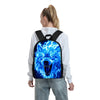 A person is wearing a black backpack featuring a blue wolf head design with an open mouth and teeth, against a white shirt.