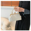 A woman holds a white pearl embellished crossbody shoulder bag against a dark clothing background.