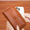 A brown PU leather fashion wallet is shown being held and opened to display various cards and a smartphone.
