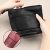 A black stretchable PU leather makeup brush storage case being held by a hand, showing the texture and closure.
