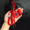 Red D-Shape nylon fitness keychain with a silicone sport bottle attached, held in a hand against a black jacket.