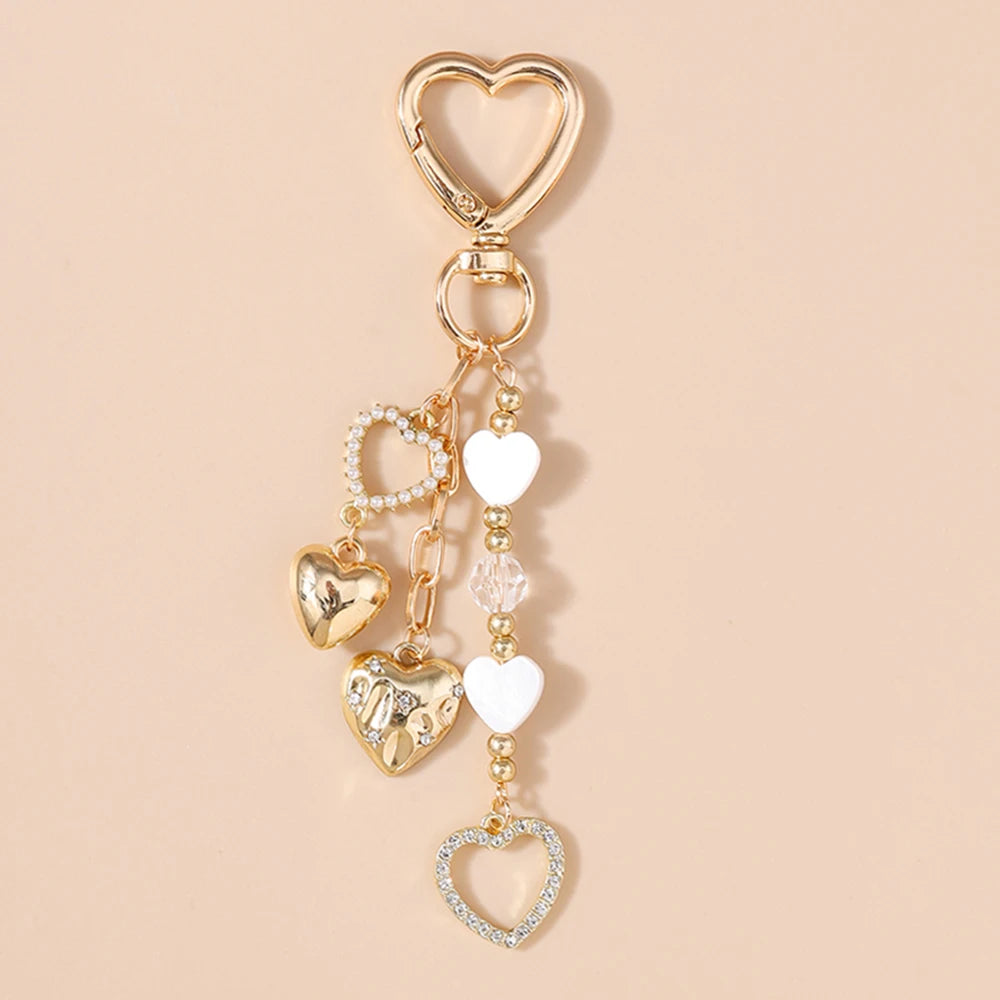 Gold-toned pearl bow heart keychain with multiple heart charms for bags and keys