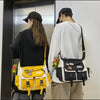 A woman wearing a black hat and white shirt carries a yellow nylon crossbody shoulder bag.