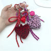 A collection of heart-shaped charm keychains featuring red, pink, and purple leopard print faux fur.