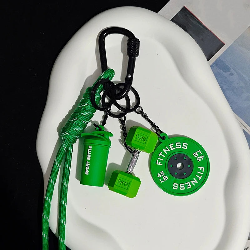 A green nylon fitness keychain with a D-shape, featuring a bottle and weights.