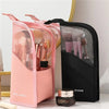 Pink and black foldable makeup brush storage cases displayed on a white surface.