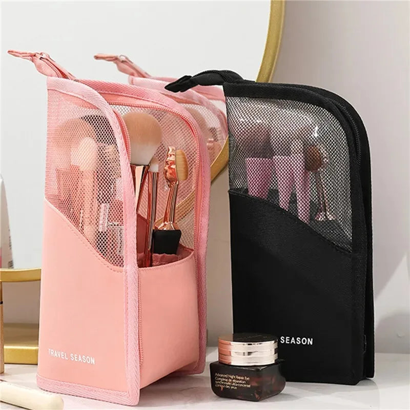 Pink and black foldable makeup brush storage cases displayed on a white surface.