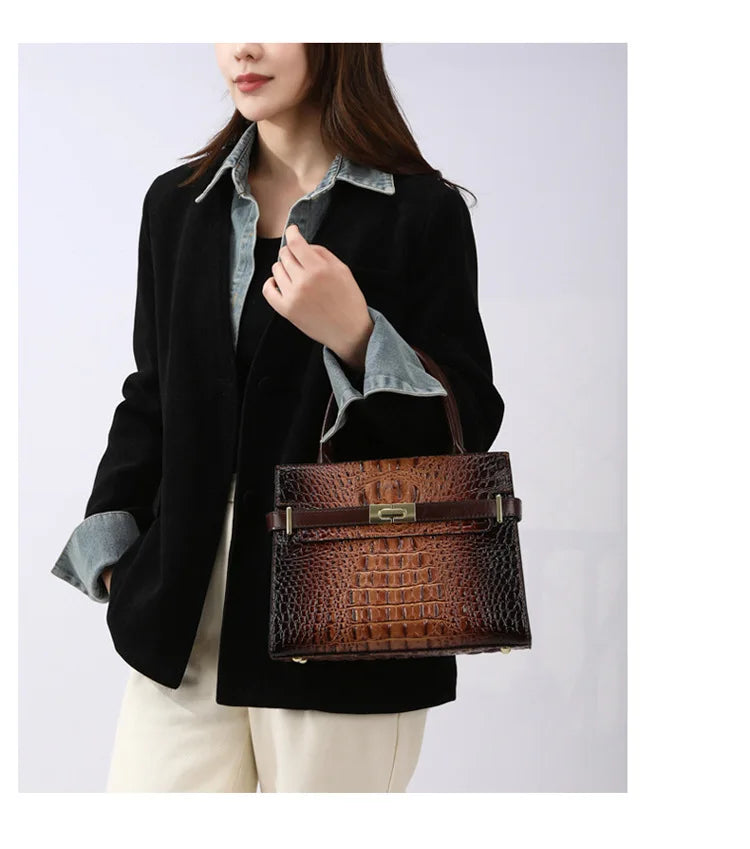 A woman models an elegant brown PU leather shoulder handbag with a dark shirt and black jacket.