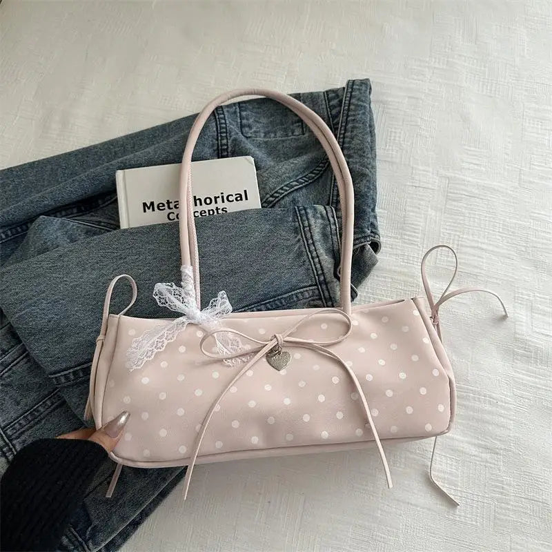 Hellrosa Retro-Polka-Dot-Schultertasche mit geflochtenem Henkel auf Denim.