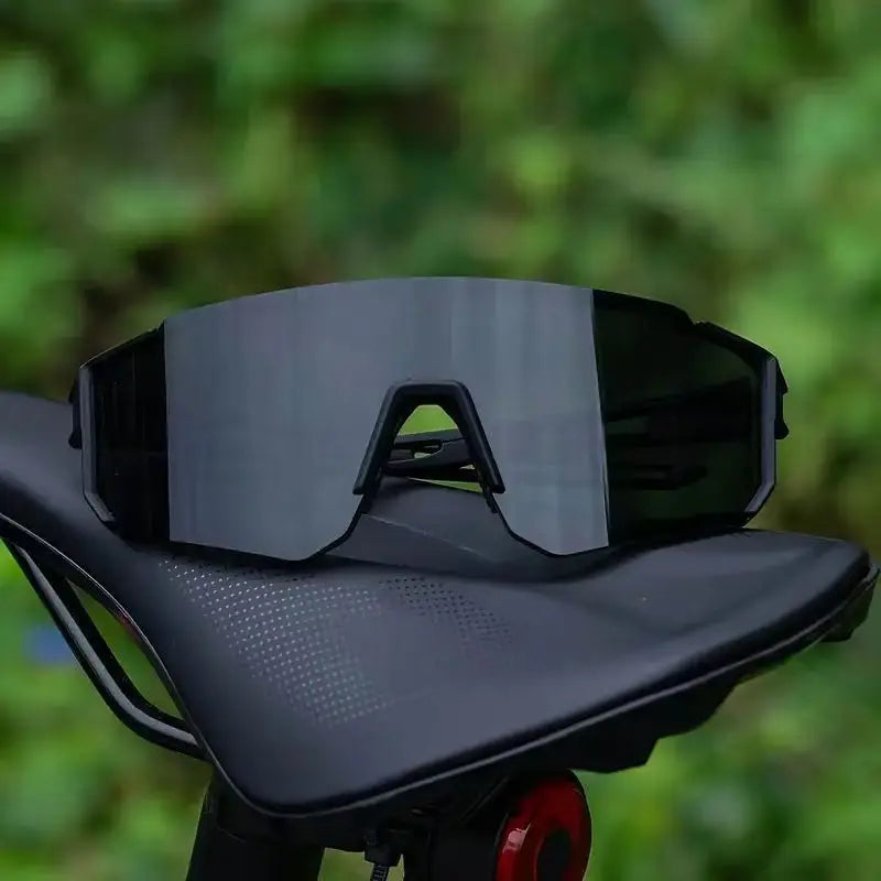 A pair of black lightweight oversized sunglasses with UV400 protection resting on a dark surface.