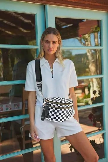 A woman models a white shirt and shorts while carrying a black and white checkered multi-functional waist bag.