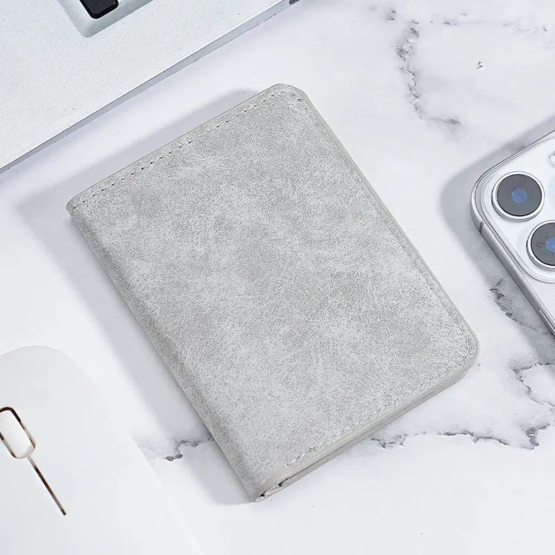 A gray ultra-thin multi-slot card wallet resting on a white marble surface.