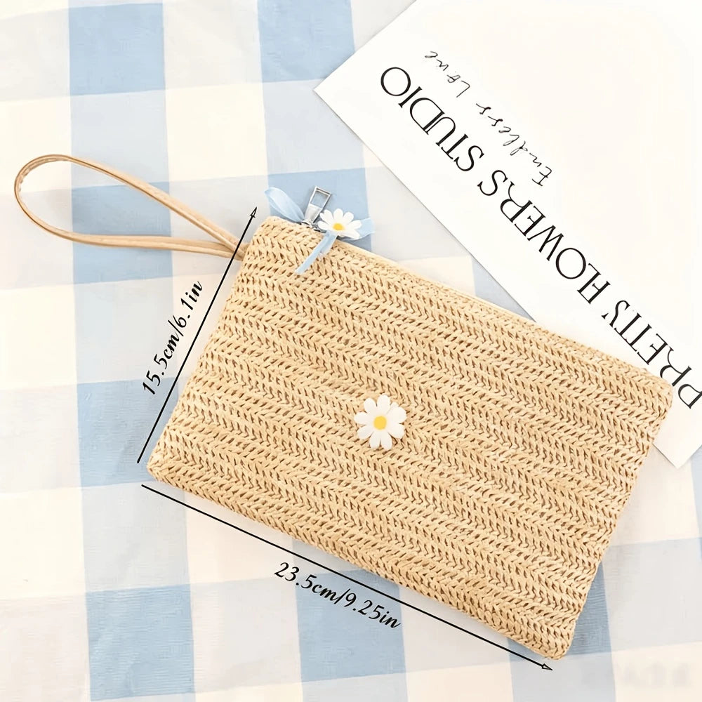 A handwoven straw makeup bag with a zipper is displayed on a blue and white checkered cloth.