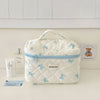 Sac de rangement cosmétique en rembourrage blanc avec motif de nœud bleu sur une surface claire.