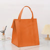 An orange insulated tote bag with a handle is displayed on a white marble surface.