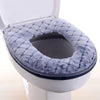 A plush, gray waterproof toilet seat cover is shown installed in a white toilet bowl.