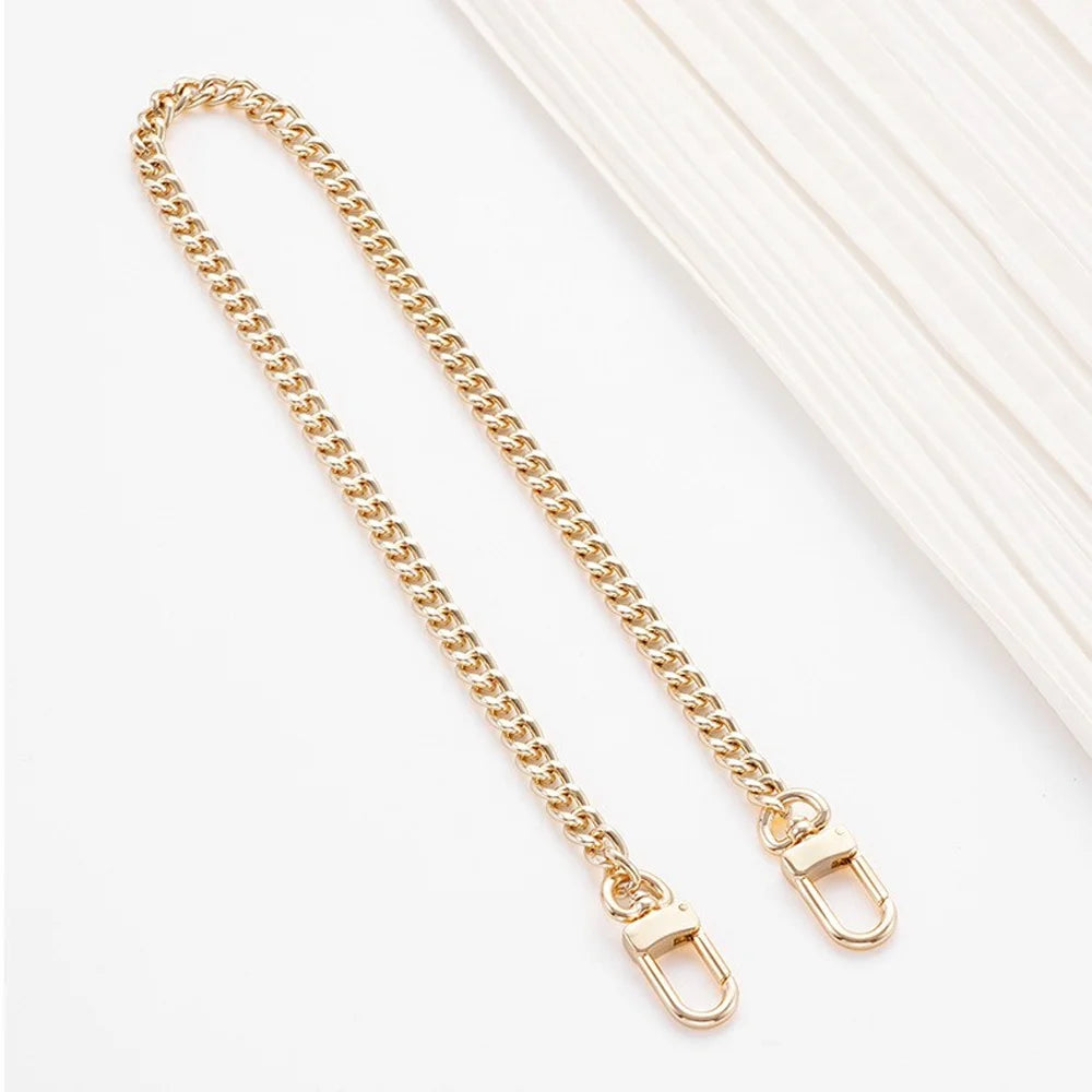 A delicate gold-tone metal chain strap with adjustable clasps shown against a white background.