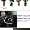 Eine Sammlung von Harz-Rosen- und Sonnenblumenblumen in Glasvasen, präsentiert im Auto-Innenraum.