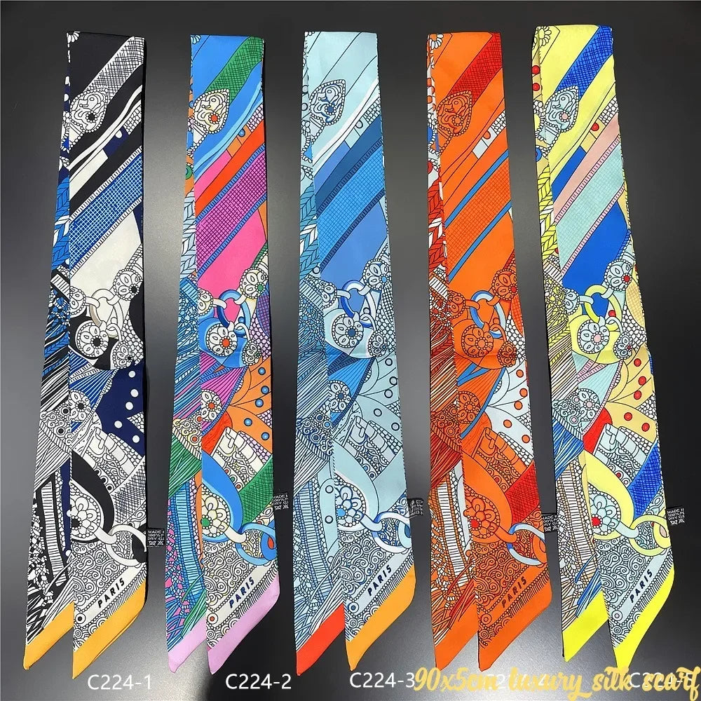 A collection of nine colorful silky twill ribbon scarves displayed vertically against a dark background.