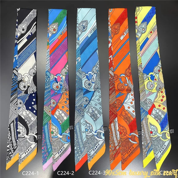 A collection of nine colorful silky twill ribbon scarves displayed vertically against a dark background.