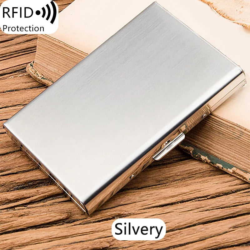 A silver stainless steel card holder with an RFID protection logo resting on a wooden surface.
