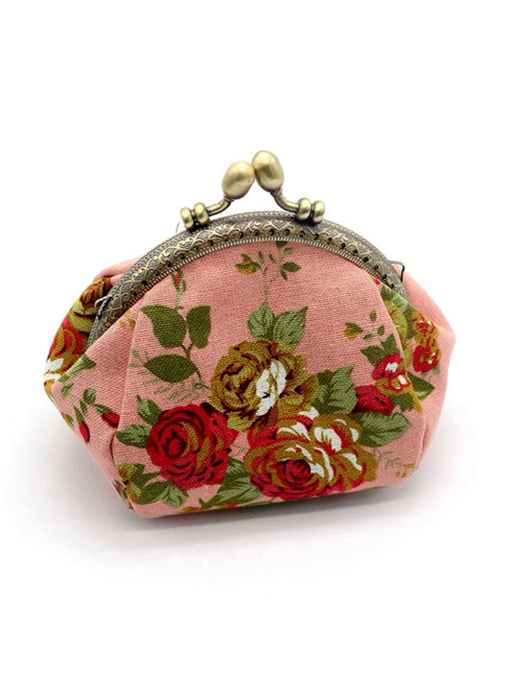 A vintage rose print canvas coin purse in pink with gold hardware.