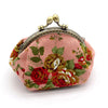 A vintage rose print canvas coin purse in pink with gold hardware.