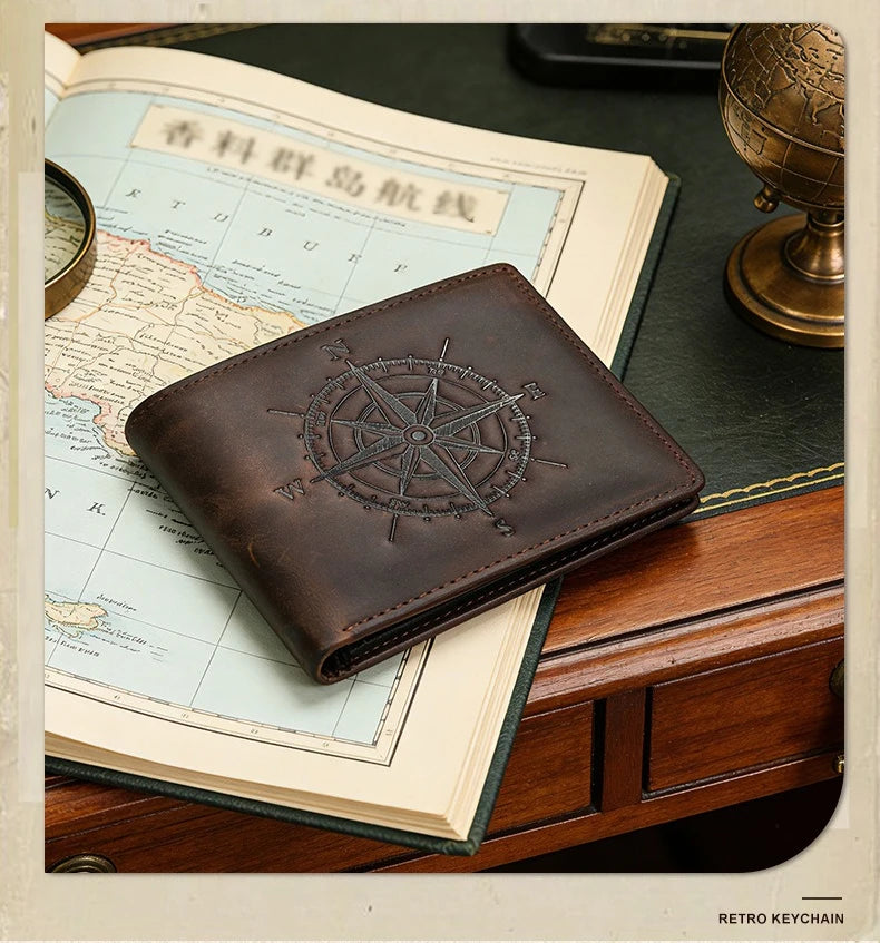 A brown leather wallet with a compass design rests on an old map and wooden surface.