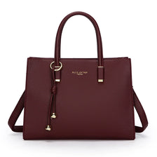 A maroon leather tote bag with gold hardware shown against a white background.