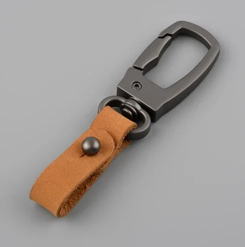 A genuine leather keyring keychain with a dark metal clasp and a tan leather strap.